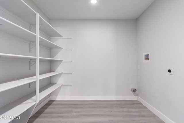 laundry room with light wood-type flooring, hookup for a washing machine, and hookup for an electric dryer