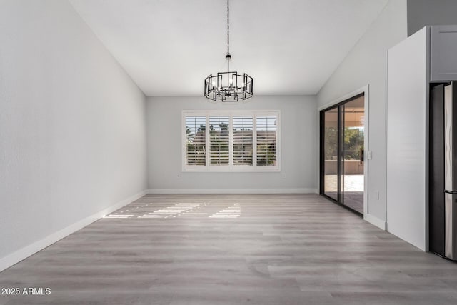 unfurnished dining area with a chandelier and light wood-type flooring