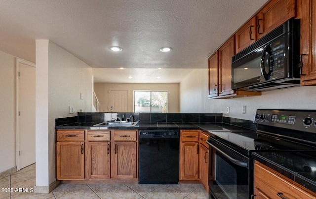19601 N 7th St Unit 1003, Phoenix, AZ 85024 - kitchen featuring black appliances, brown cabinetry, a peninsula, dark countertops, and recessed lighting