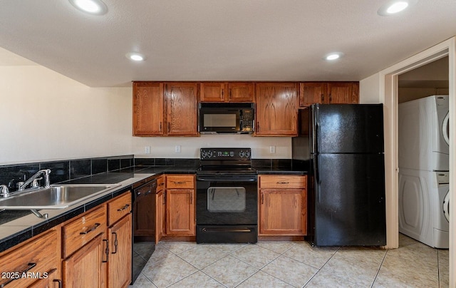 19601 N 7th St Unit 1003, Phoenix, AZ 85024 - kitchen featuring black appliances, estacked washer and dryer, brown cabinetry, recessed lighting, and light tile patterned floors