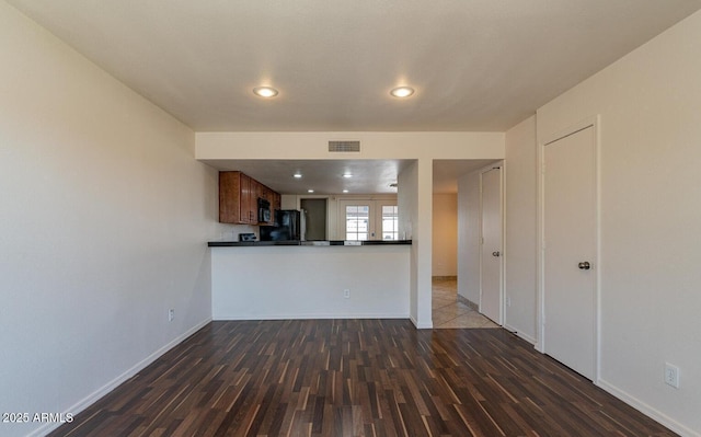 19601 N 7th St Unit 1003, Phoenix, AZ 85024 - kitchen with black appliances, dark countertops, dark wood-type flooring, recessed lighting, and brown cabinetry