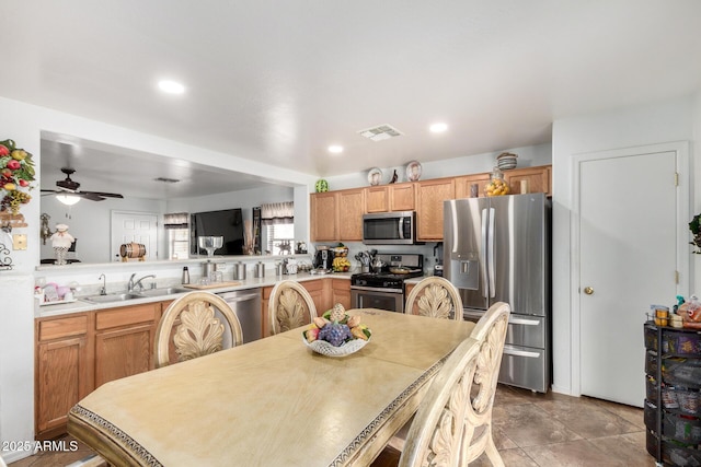 dining area featuring light tile patterned flooring, ceiling fan, and sink