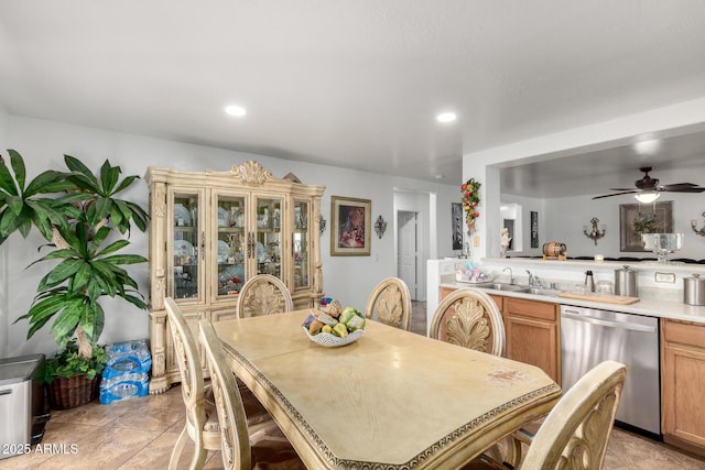 tiled dining room with ceiling fan and sink