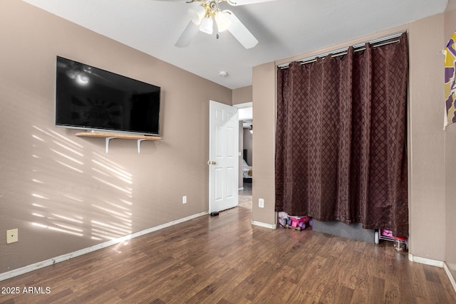 unfurnished bedroom with ceiling fan, a closet, and dark hardwood / wood-style floors