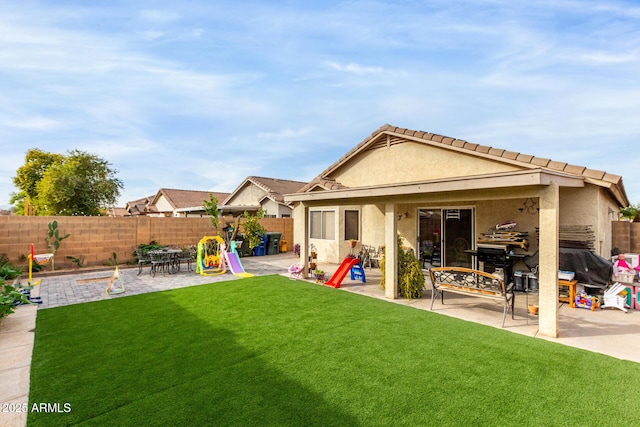 back of property with a patio and a lawn