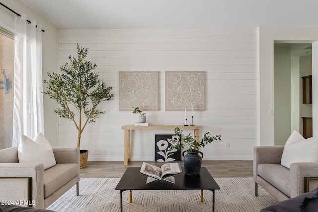 living room with wooden walls and light hardwood / wood-style flooring