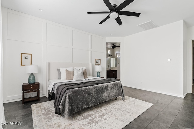 bedroom with dark tile patterned floors, ensuite bath, and ceiling fan