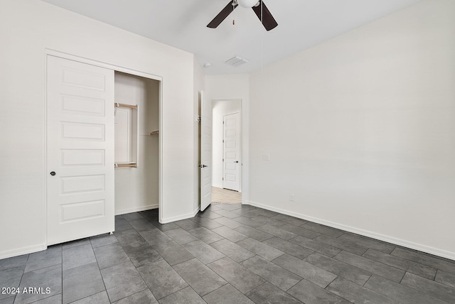 unfurnished bedroom with ceiling fan and a closet