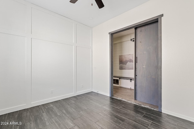 unfurnished bedroom with ceiling fan, a closet, and dark hardwood / wood-style floors