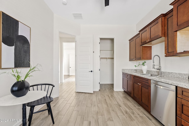 kitchen featuring light stone counters, light hardwood / wood-style flooring, stainless steel dishwasher, and sink