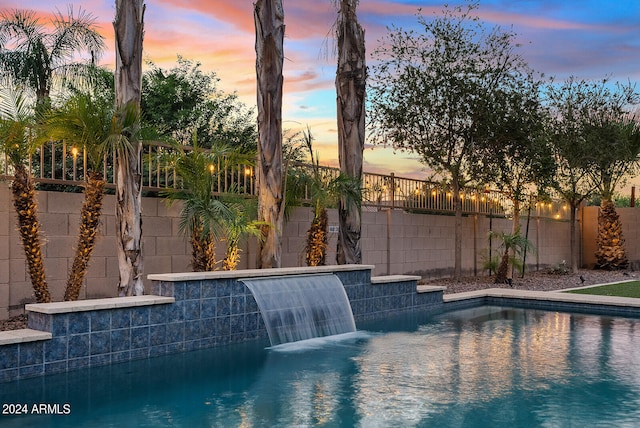 pool at dusk with pool water feature