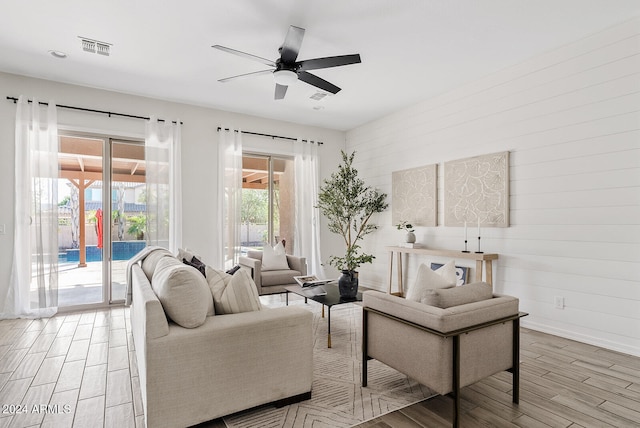 living room with light hardwood / wood-style flooring and ceiling fan