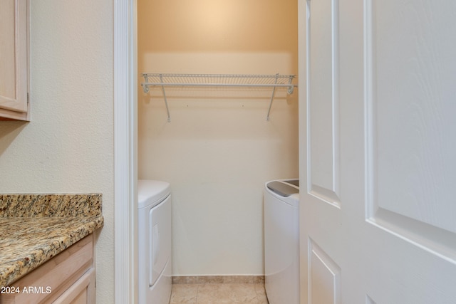 laundry area with light tile patterned flooring and independent washer and dryer