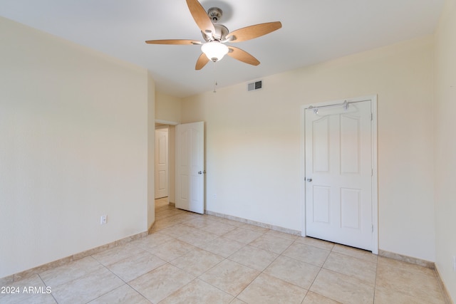 tiled spare room featuring ceiling fan