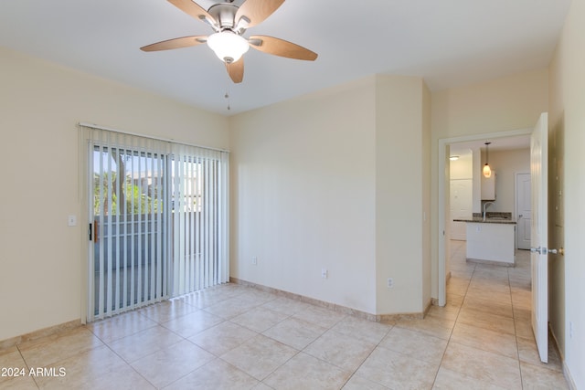 tiled spare room featuring ceiling fan