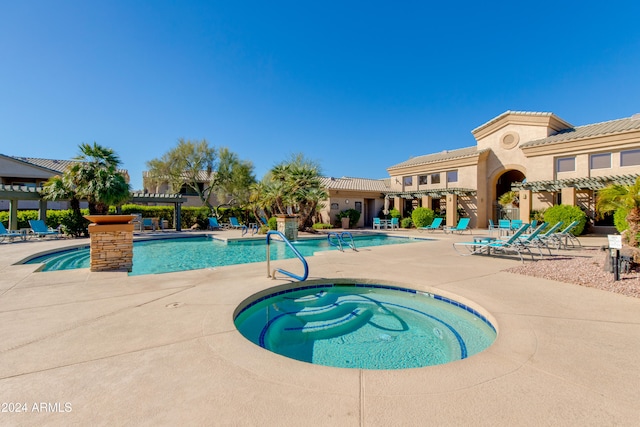 view of swimming pool with a hot tub and a patio area