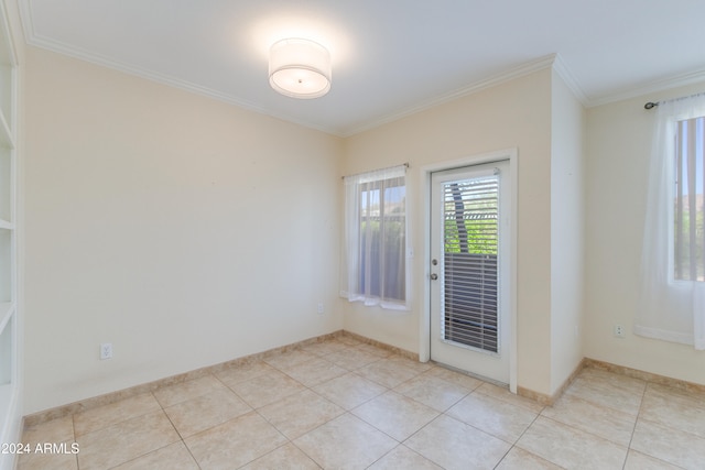 empty room featuring crown molding and light tile patterned floors