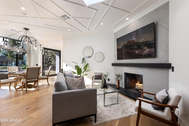 living room with a premium fireplace, an inviting chandelier, hardwood / wood-style floors, and a wall of windows