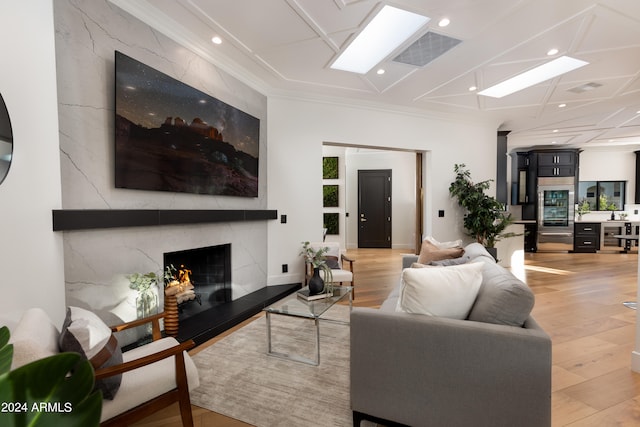 living room featuring light hardwood / wood-style floors, ornamental molding, and a premium fireplace