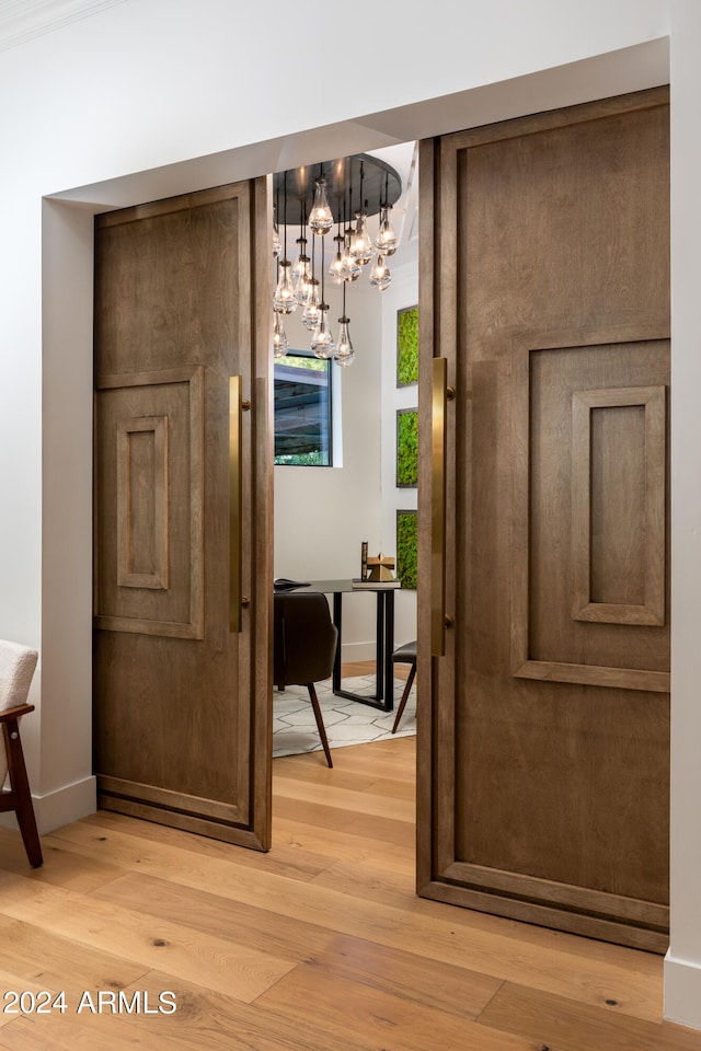 foyer with light hardwood / wood-style floors and a notable chandelier