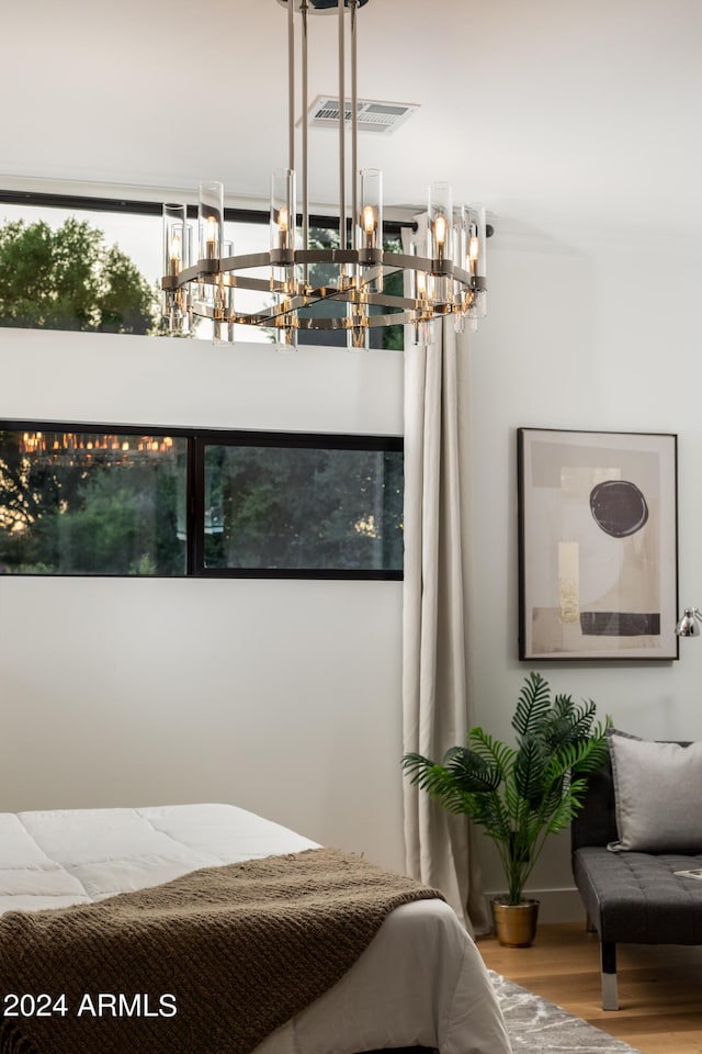 bedroom featuring a notable chandelier and wood-type flooring