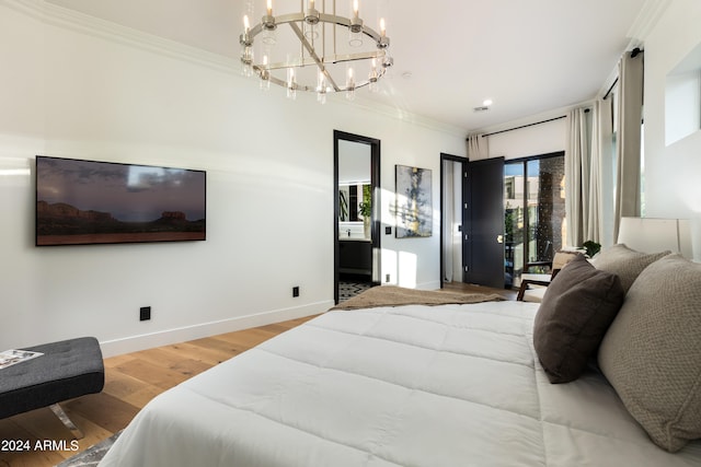 bedroom with wood-type flooring, ornamental molding, and an inviting chandelier