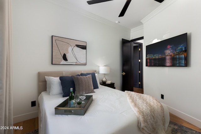 bedroom featuring wood-type flooring, ornamental molding, and ceiling fan