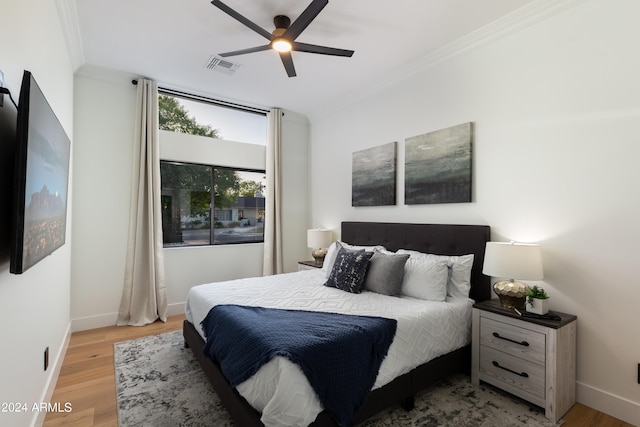 bedroom featuring ceiling fan, ornamental molding, and light hardwood / wood-style floors