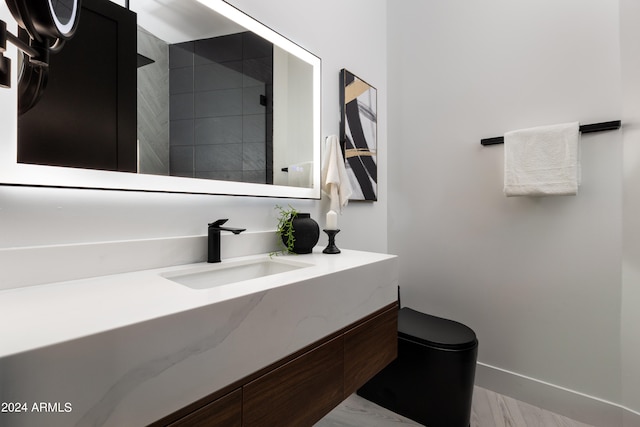 bathroom with hardwood / wood-style flooring, vanity, and toilet