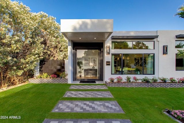 entrance to property featuring a yard