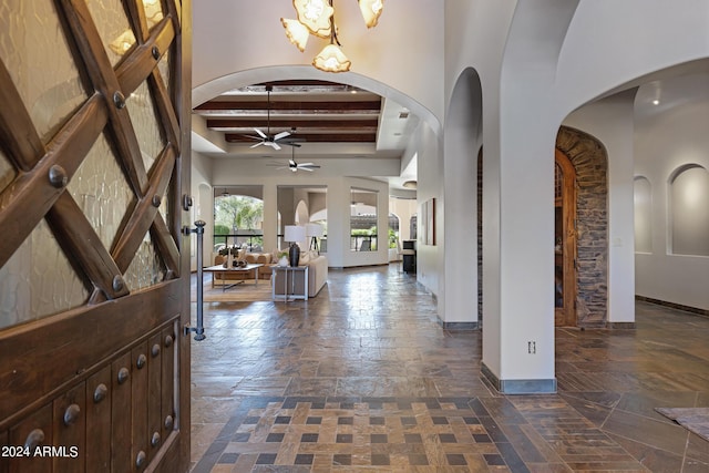 entrance foyer with beamed ceiling and ceiling fan with notable chandelier