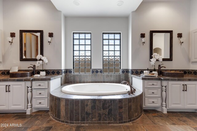 bathroom with vanity and tiled bath