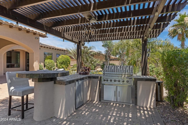 view of patio / terrace with a pergola, a grill, a bar, and an outdoor kitchen