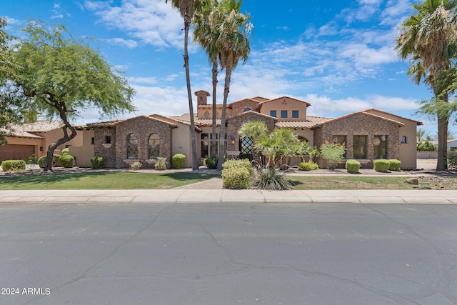 mediterranean / spanish home with a front lawn