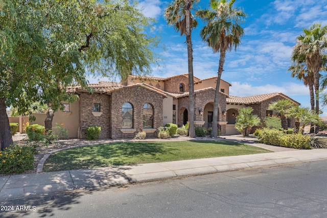 mediterranean / spanish-style home featuring a front yard