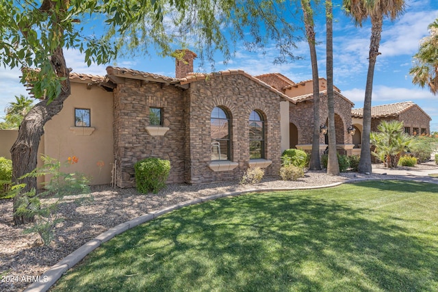 mediterranean / spanish home featuring a front lawn