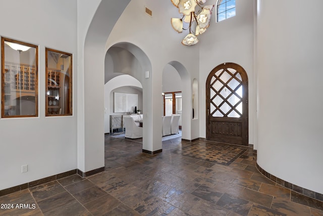 entryway with a high ceiling and an inviting chandelier