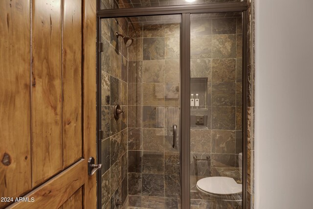 bathroom featuring toilet and an enclosed shower