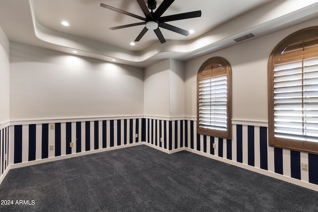 unfurnished room with carpet floors, a tray ceiling, and ceiling fan