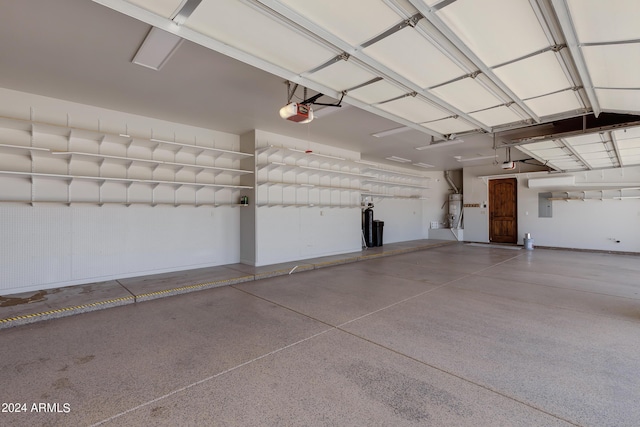 garage with secured water heater, electric panel, and a garage door opener