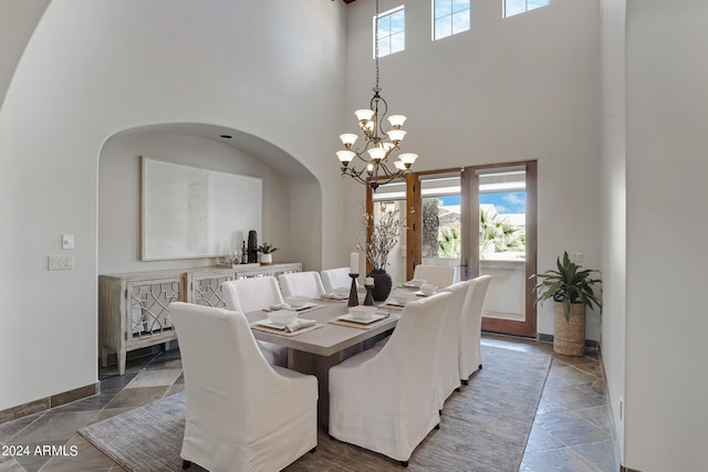 dining space with a notable chandelier and a towering ceiling