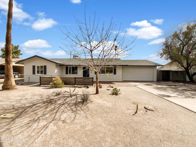 single story home featuring brick siding, an attached garage, driveway, and fence