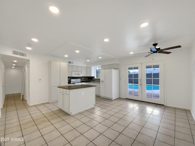 kitchen with visible vents, white appliances, dark countertops, and french doors