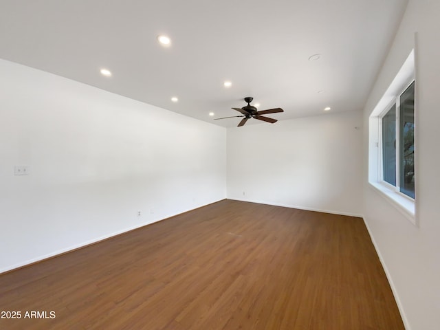 empty room featuring recessed lighting, baseboards, wood finished floors, and a ceiling fan