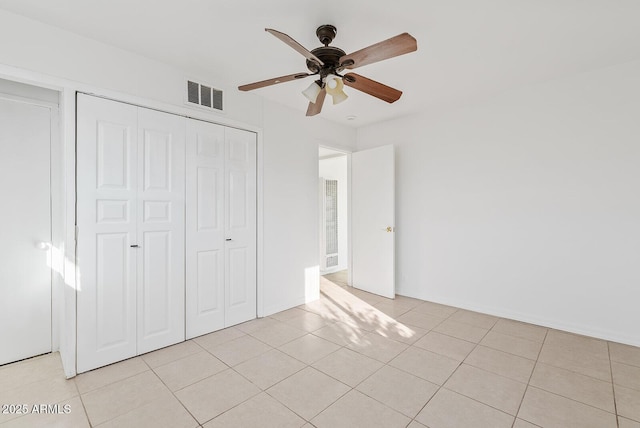 unfurnished bedroom featuring light tile patterned floors, ceiling fan, and a closet