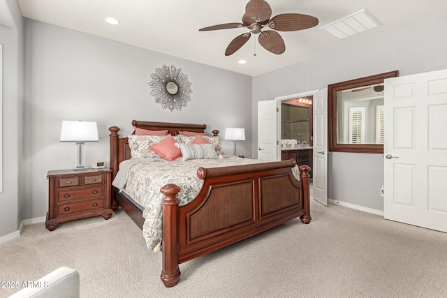 bedroom with recessed lighting, light colored carpet, ensuite bath, and baseboards