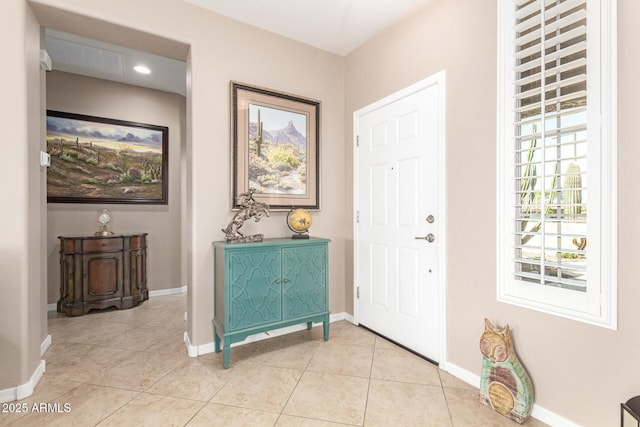 foyer featuring a wealth of natural light, light tile patterned floors, and baseboards