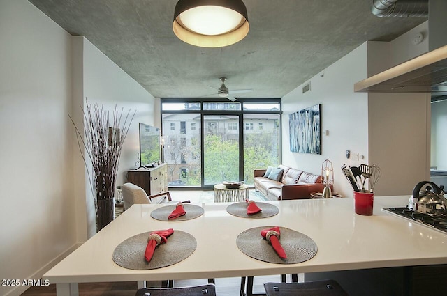 dining room featuring visible vents, a ceiling fan, and floor to ceiling windows