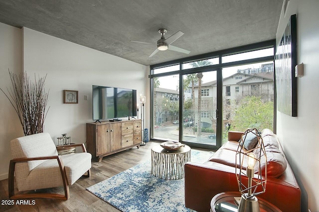 interior space featuring a ceiling fan, floor to ceiling windows, and wood finished floors