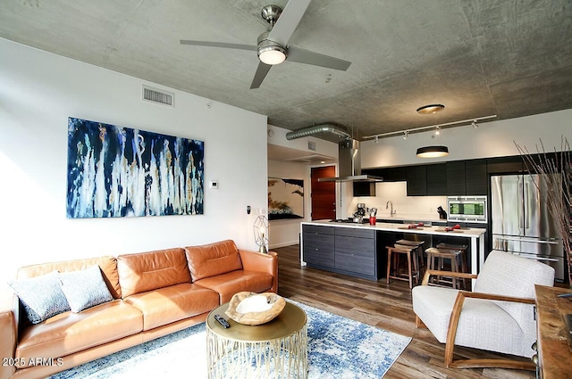 living room featuring ceiling fan, dark wood-style flooring, visible vents, and track lighting